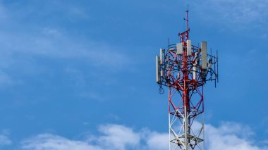 Açık mavi gökyüzüne kurulmuş bir telekomünikasyon kulesi modern bağlantıyı ve kablosuz iletişim teknolojisini simgeliyor..
