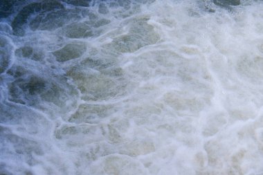 Okyanus dalgalarının çarpışması, dinamik deniz manzarasında karmaşık beyaz köpük desenleri yaratır..