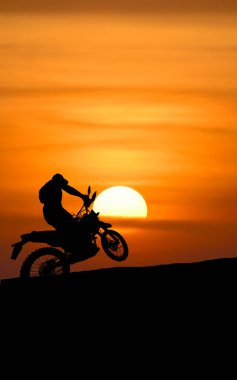 Gün batımında arka planda güzel bir gökyüzü olan motosiklet silueti..