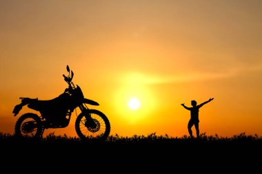 Çöl manzarasında motosikletli bir adamın silueti..