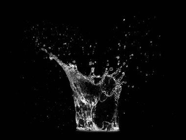 Suyun siyah zemine sıçrayıp dinamik hareketi ve akıcılığı yakaladığı yüksek çözünürlüklü görüntü..