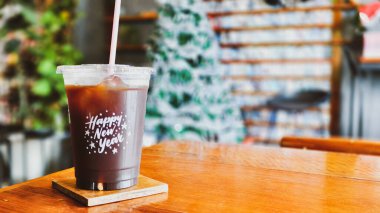 Yılbaşı süslemeleri olan bir kafede buzlu kahve, samimi ve davetkar bir ortam yaratıyor..