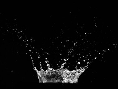 Siyah arka planda su sıçramasının yüksek hızda yakalanması dinamik hareket ve enerjiyi gösteriyor..