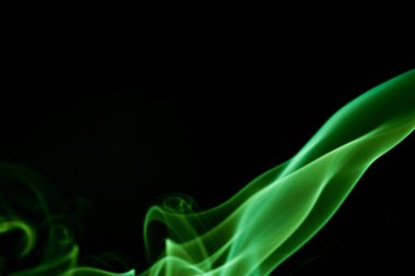Siyah bir arkaplanda kıvrılan yeşil dumanın büyüleyici görüntüsü gizem ve zarafeti çağrıştırıyor..