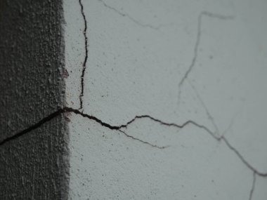 Çatlak bir beton duvarın ayrıntılı görüntüsü, sergilenen doku ve doğal desenler, arka plan veya tasarım projeleri için ideal.