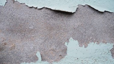 Yeşil boyalı beton bir duvarın yakın çekimi altında gri bir yüzey ortaya çıkarıyor..