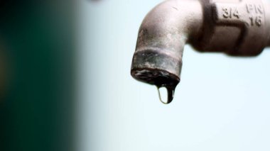 Damlayan bir musluğun detaylı görüntüsü, su koruma ve tesisat sorunlarını vurguluyor.