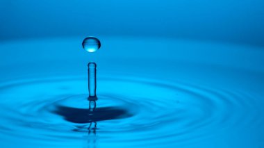 Mavi arkaplana düşen bir damla su