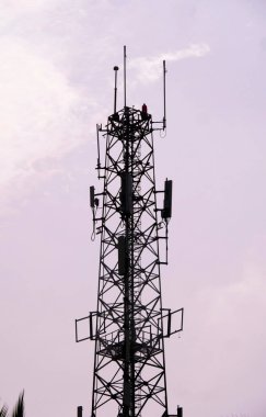 Açık bir gökyüzüne karşı, teknoloji ve telekomünikasyon temaları için ideal anten ve yemeklerle yüksek bir iletişim yapısı..