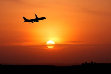 Günbatımı sırasında gökyüzünde uçan uçak