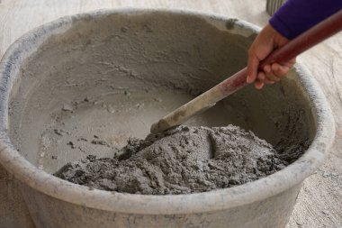 İşçiler çimentoya ıslak çimento karıştırıcı leğen kullanıyorlar, seçici odak                              