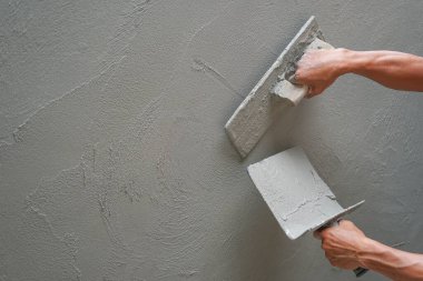 İnşaat alanındaki beton duvarı kopyalayan işçilerin eli, seçici odaklı.                                                           