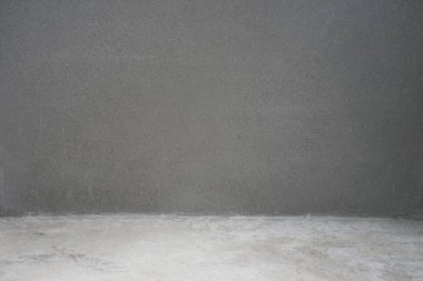 Yeni beton duvar, inşaat alanında kirli grunge zemini olan ince harç kaplamalı duvar.                              