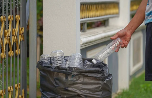 Χέρι Ρίχνει Ένα Πλαστικό Μπουκάλι Μια Σακούλα Σκουπιδιών Μπροστά Από — Φωτογραφία Αρχείου