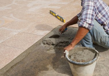 Yere sermek için bir kovada malalı ve karışık havan toplu işçi, seçici bir odak.                               