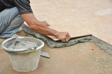 tiler inşaat sahasındaki karışık havan mermisinin üzerine fayans yerleştiriyor