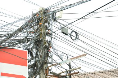 Şehirdeki sokak lambası direğindeki elektrik kabloları ve iletişim kabloları beyaz arka planda izole edilmiş. seçici odaklanma. Konsept risk yönetimi ve güvenlik