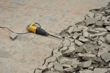 Kaya matkabı yere bırakılmış, arka plan kırılmış beton. Seçici odaklanma.