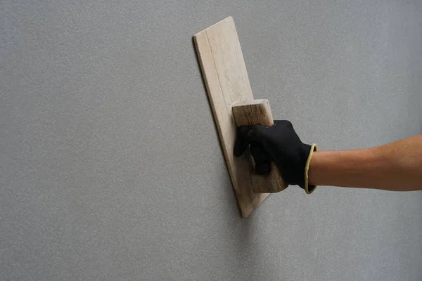 Yaşlı bir adam elinde odun kürekle evde beton duvarlar örüyor. Yaşlılarda bir hobi, seçici bir odak noktası.                                                              