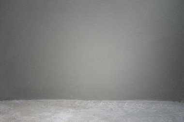 Yeni beton duvar, inşaat alanında kirli grunge zemini olan ince harç kaplamalı duvar.                                                                                            