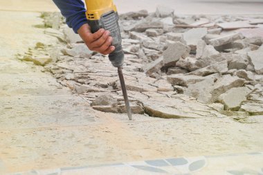 Yere beton dökmek için matkap tutan el, seçici odaklanma