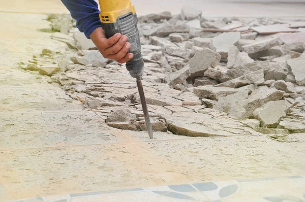 Yere beton dökmek için matkap tutan el, seçici odaklanma