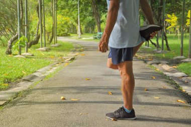Yaşlı erkek bacakları koşmadan ya da parkta koşmadan önce ısınıyor, konsept ısınma egzersizi yaşlı insanlarda yaralanmayı önlüyor                                                                                 