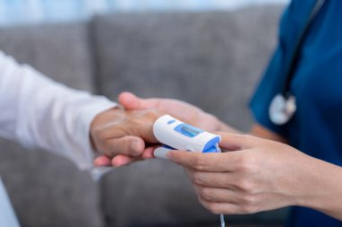 Steteskoplu kadın elleri nabız ölçer, yaşlı kadın, sağlık çalışanı ya da eski bir hastayı muayene ediyor.