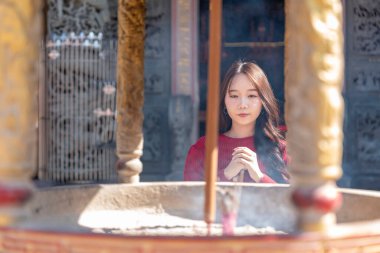 Genç Asyalı kadın tütsü ocağında dua ediyor Çin tapınağında, Çin Yeni Yıl konsepti