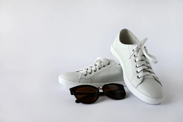 白色时髦女式运动鞋和太阳镜与白色背景隔离 运动鞋和休闲鞋 复制空间 — 图库照片