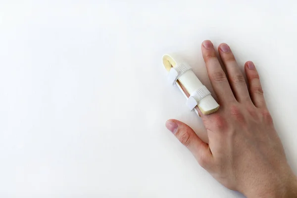 medical splint on a broken finger, on a white background. Medical assistance in case of injury. Copy space