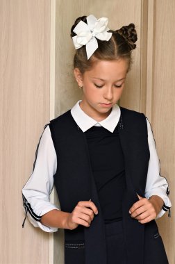 Saçları beyaz kurdeleli güzel bir kız ve okulun ilk gününde güzel bir okul üniforması var. Okula dönelim. Bilgi Günü.