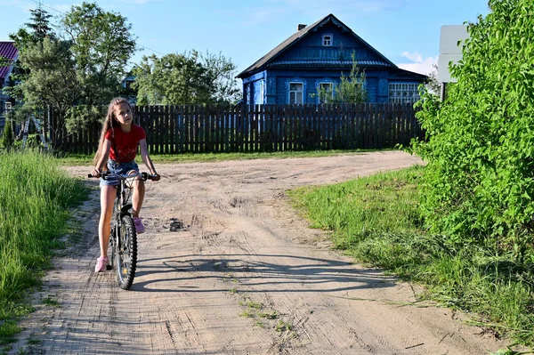 Słodka Nastolatka Długimi Włosami Uczy Się Jeździć Rowerze Ulicami Letniej — Zdjęcie stockowe