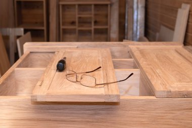 Özel yapım mobilya üretimi. Dolaptaki bardaklar ve tornavida açık renkli doğal ahşaptan elde yapılır. Seçici Odaklanma