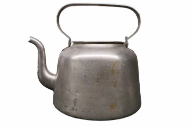 A classic metal kettle sits on a flat surface, featuring a curved spout and a sturdy handle. Its weathered surface shows rust and scratches, indicating extensive use, perfect for boiling water.