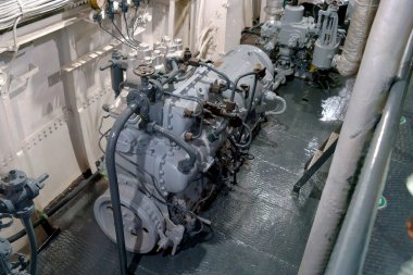 Ziyaretçiler, gemiye güç veren karmaşık makine ve hidrolik sistemleri gözlemleyerek bir donanma gemisinin makine dairesini keşfediyorlar. Bölgede deniz mühendisliği sergileniyor.