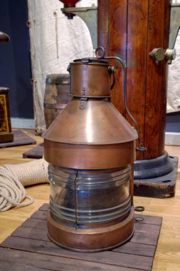 Cam pencereli klasik bir pirinç fener bir deniz müzesinde belirgin bir şekilde sergileniyor. Denizcilik tarihini ve denizcilerin kullandığı aletleri temsil ediyor. Ayarlar çeşitli denizcilik eserlerini içeriyor.