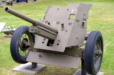 Bu tarihi topçu parçası bir askeri müzede duruyor, geçmiş savaşlarda kullanılan tasarım ve teknolojiyi vurguluyor. Silah, monte edilmiş bir fıçı ve sağlam tekerlekler içeriyor..