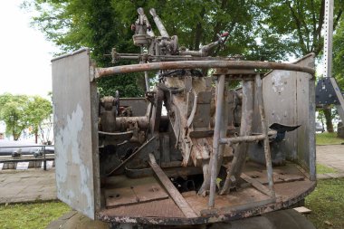 Bu askeri top mermisi, yemyeşil ağaçlarla çevrili halka açık bir park ortamında sunuluyor. Tarihsel ve yıpranma belirtileri gösteriyor. Ziyaretçilerin merakını uyandırıyor..
