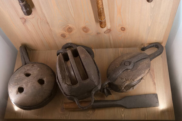 Various old tools are arranged on a wooden backdrop, illustrating the history of craftsmanship. The collection includes unique shapes and textures, representing traditional manual work.