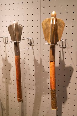 Müzedeki bir sergi duvarına iki farklı tarihi alet monte edilir. Her araç kendi zamanlarının işçiliğini vurgulayan eşsiz şekil ve materyallere sahiptir..