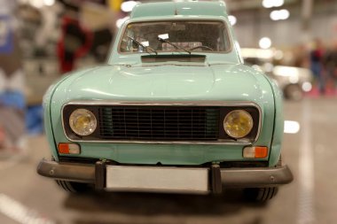 Otomobil sergisinde sergilenen klasik nane yeşili araba. Araç, klasik otomotiv tarzının özünü yansıtan yuvarlak sarı farlar ve retro bir tasarıma sahip..