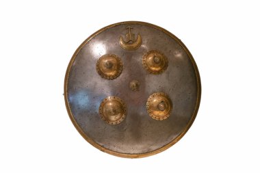 Yuvarlak kalkanda farklı dekoratif elementler ve desenlerle metalik bitişler bulunur. Tarihi önemini yansıtan bir müze ortamında sergileniyor..