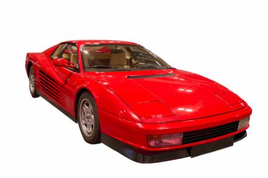 Parlak kırmızı bir spor araba bir müzenin içine park edilmiştir. Arabanın düz çizgileri olan parlak bir tasarımı var. İyi korunmuş ve belirgin özelliklerini sergiliyor..