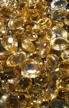 Bir altın taş koleksiyonu birbirine yakın olarak düzenlenir. Taşlar şekil ve boyut olarak değişir. Işık yüzeylerinden yansıyarak ışıl ışıl bir etki yaratıyor..