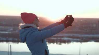 Kız bir selfie gün batımında yapar.
