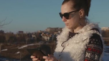 Tablet ve gülümser günbatımında oynayan kız