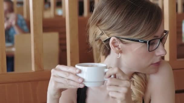 Жінка п'є чай в кафе — стокове відео