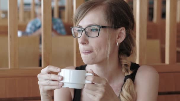 Tjej dricker kaffe i caféet — Stockvideo