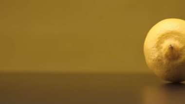 Sarı arka planda siyah bir masada limonlu rulo. Kapat..